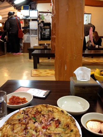 Sitting on the floor of a traditional restaurant eating a seafood pancake and kimchi :)